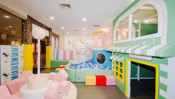 Ein Kinderspielbereich mit Bällebad, Rutsche und Spielhaus.