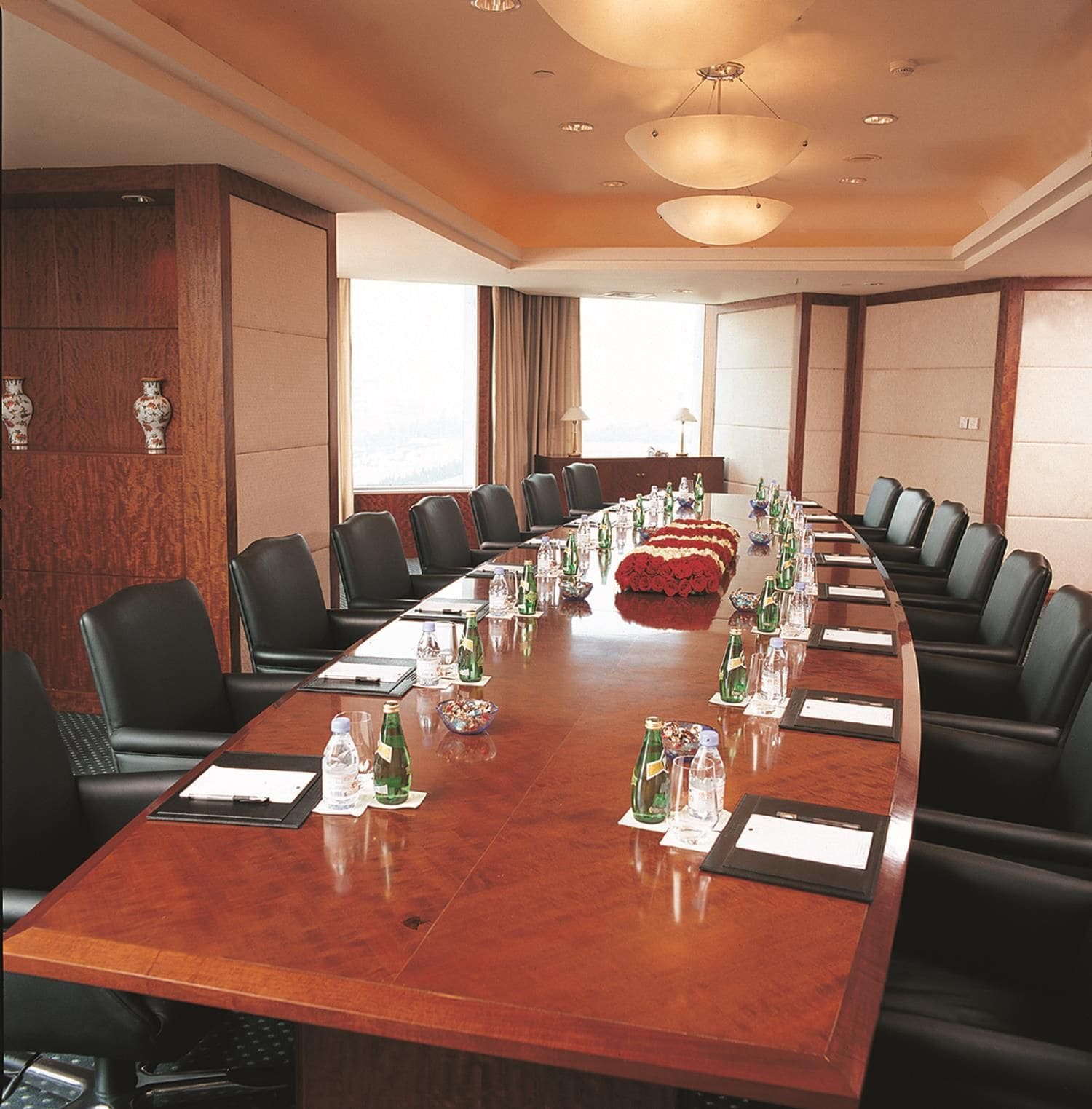 A conference room with a long table, chairs, and water bottles.