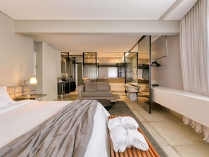A modern hotel room with a bed, a seating area, a bathroom, and a kitchenette. - Mercure Belo Horizonte Vila Da Serra Hotel (Nova Lima)