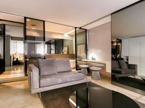 Un salon moderne comprenant un canapé, une table basse et un coin repas avec des chaises.
