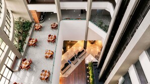 A multi-level atrium with open-plan seating areas, a central lounge, and a visible staircase.