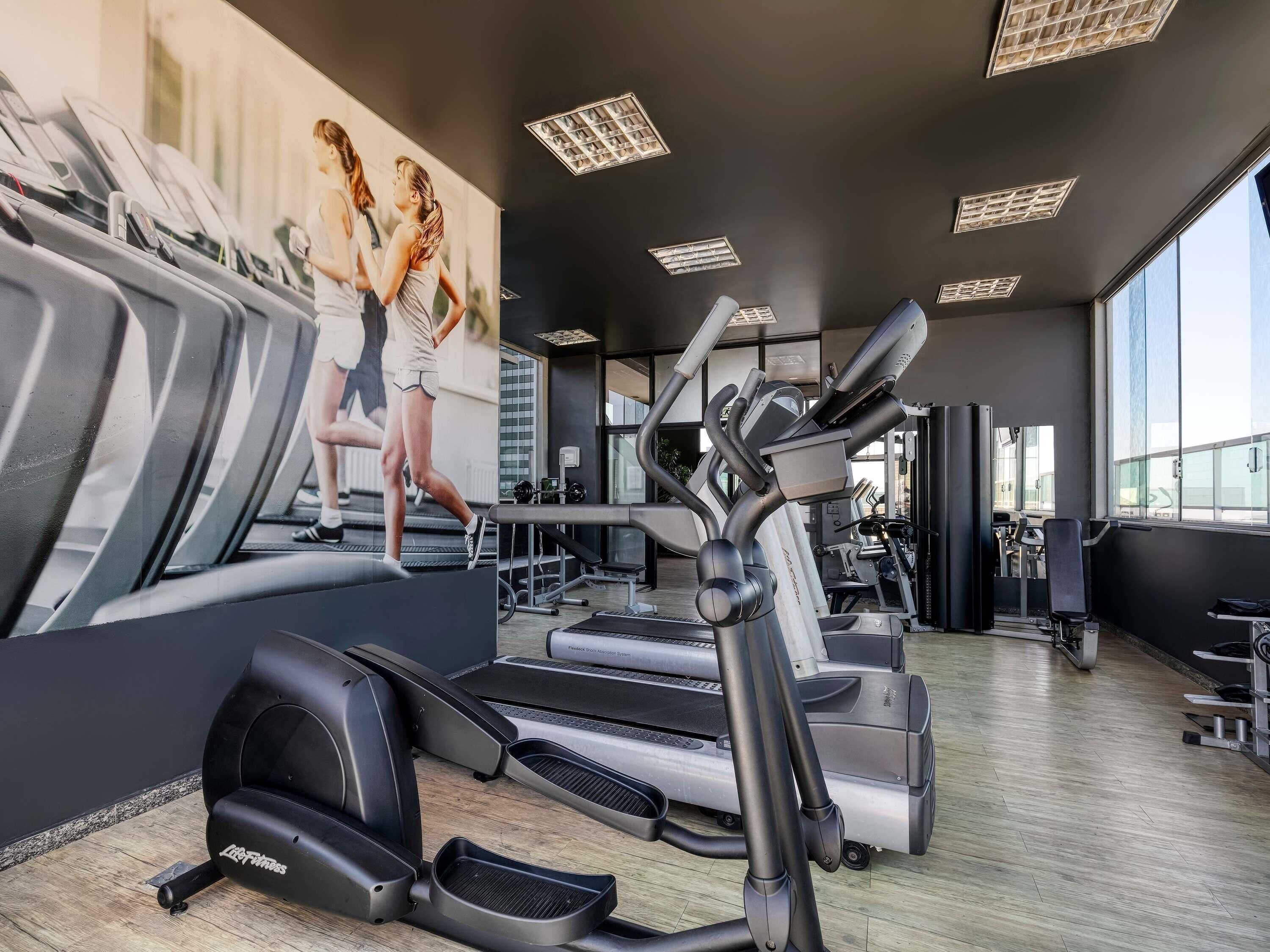 A gym with treadmills, elliptical machines, and weight equipment.