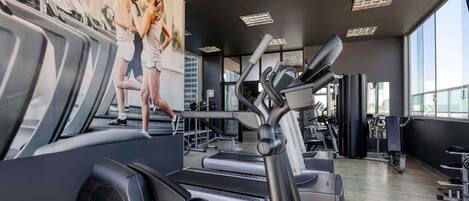 A gym with treadmills, elliptical machines, and weight equipment.