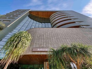 A modern building with a curved facade, large windows, and a sign that reads 'Mercury'. - Mercure Belo Horizonte Vila Da Serra Hotel (Nova Lima)
