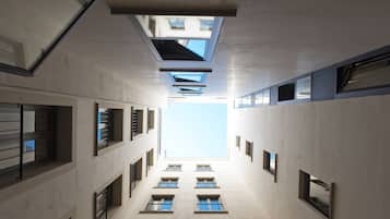Un bâtiment moderne doté d’un atrium central, de verrières et de nombreuses fenêtres.