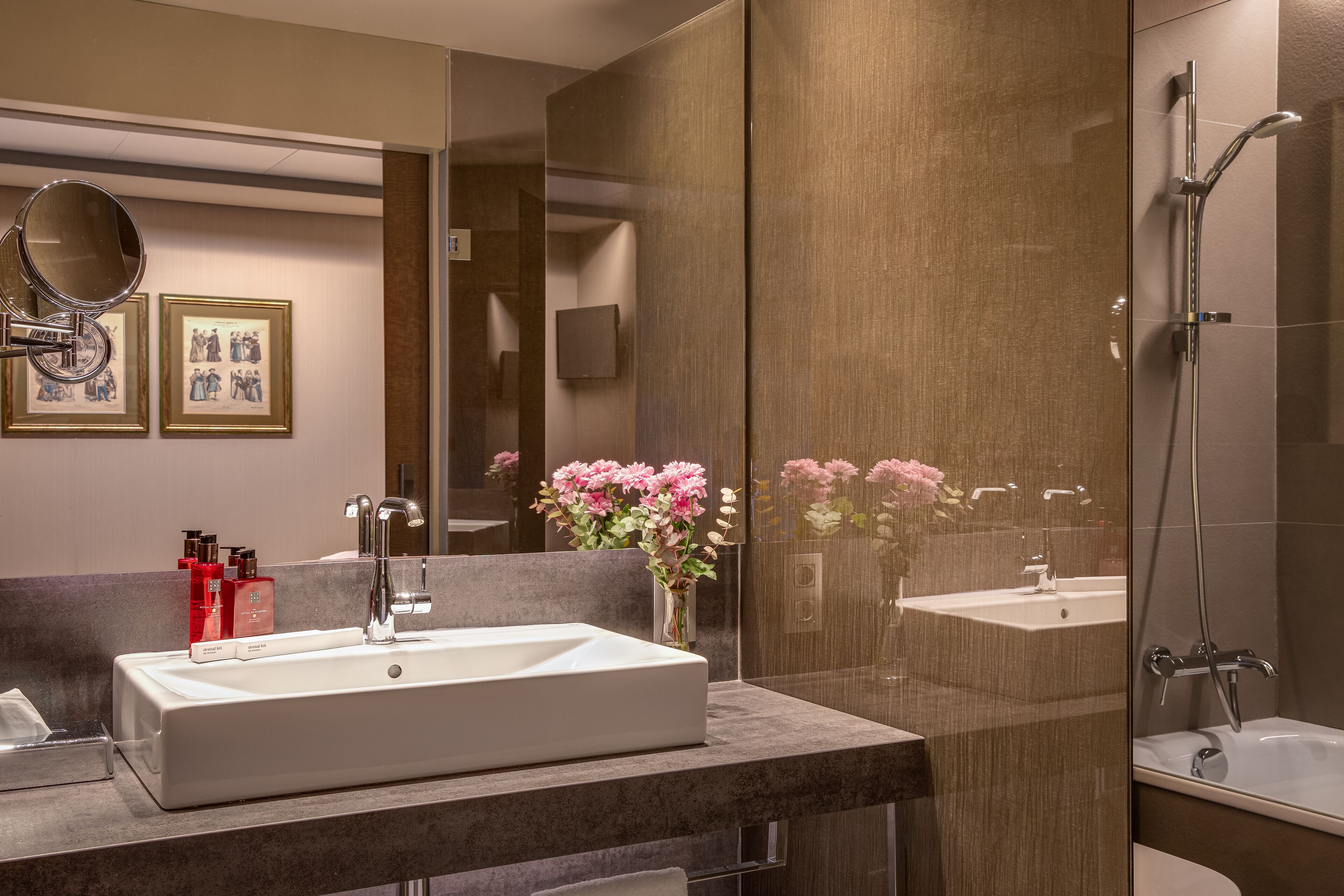 Un baño moderno con un espejo grande, un lavamanos y una ducha.