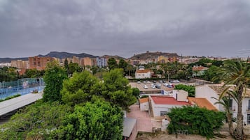 Un pueblo costero con edificios, un área de estacionamiento y vista al mar.