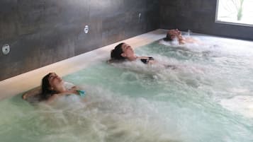 Et spaområde med tre personer, der slapper af i en jacuzzi.