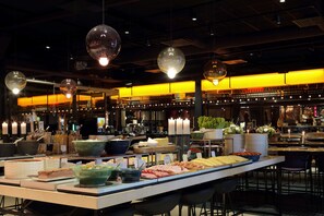 A buffet setup with various food items and a bar area in the background. - Scandic Europa (Gothenburg)