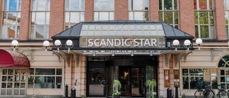 L’extérieur de l’hôtel Scandic Star se distingue par son entrée imposante, ses grandes fenêtres et un tapis rouge menant à la porte.