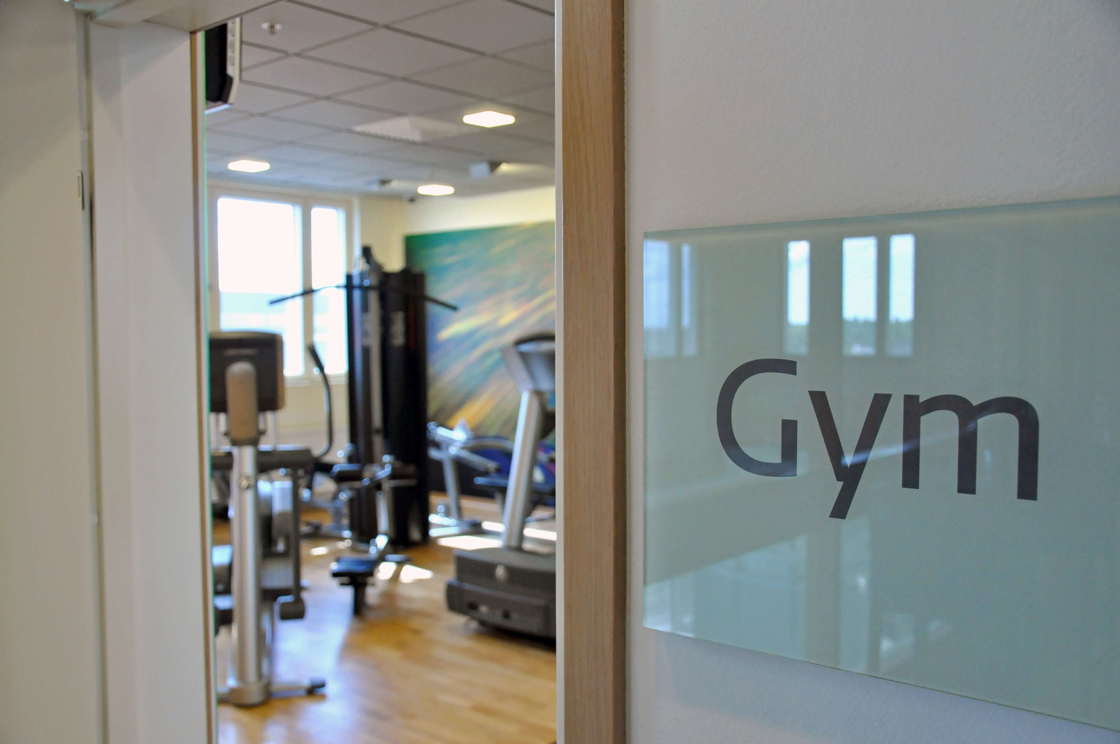 Un gimnasio con equipo de ejercicio y un cartel que dice 'Gym'.