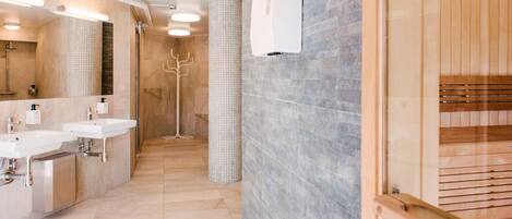 Un baño moderno con dos lavamanos, un espejo y una zona de ducha.