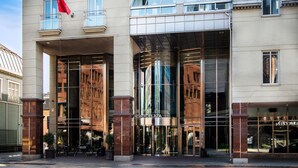 Un edificio moderno con un llamativo letrero 'Scandic', amplias ventanas de vidrio y una entrada central.