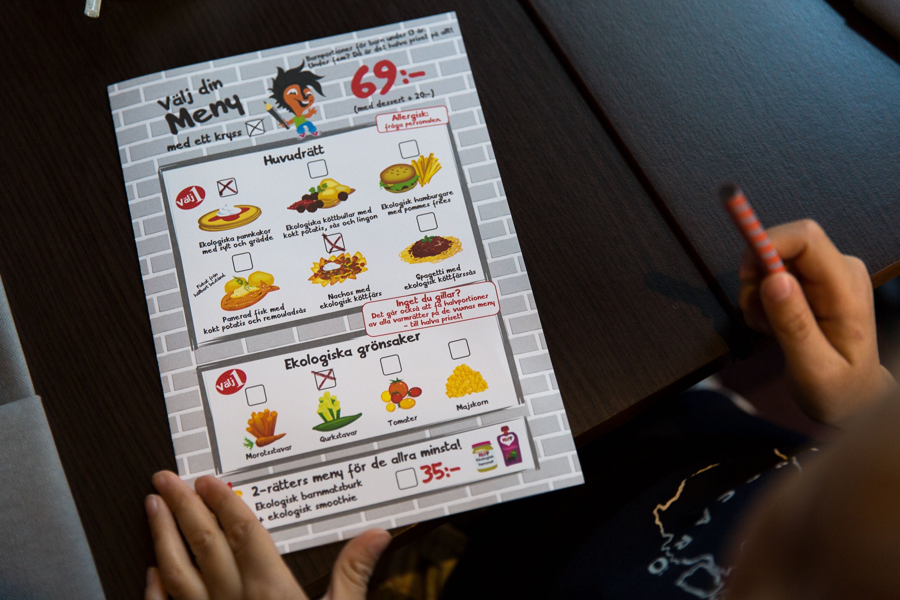 A person holding a menu with various food items and a score of 69.