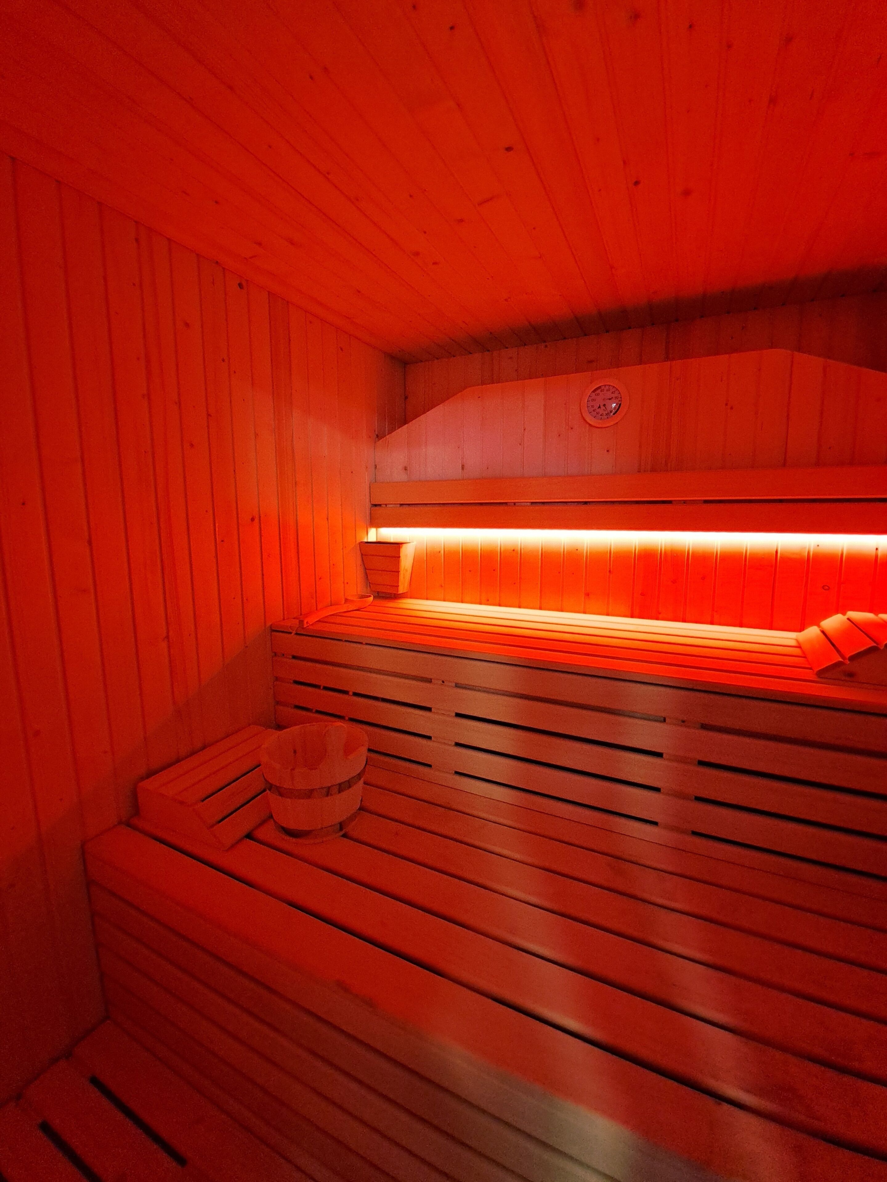 A sauna with wooden benches and a bench with a towel.