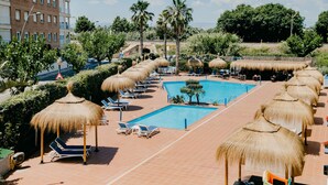 A rooftop pool area with lounge chairs, thatched umbrellas, and a swimming pool. - Sol Port Cambrils (Cambrils)