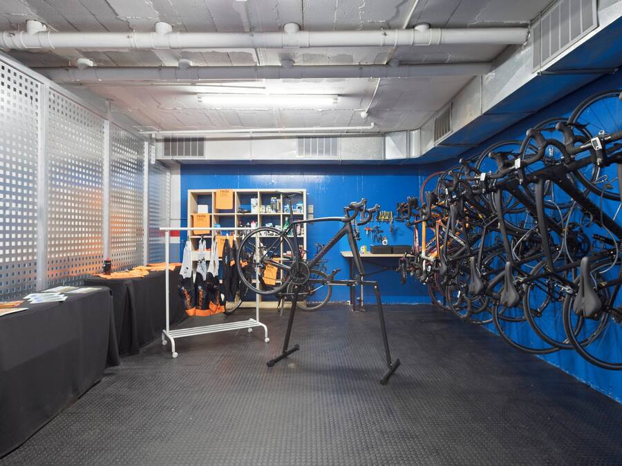 A room with a blue wall, a bike rack, and a table with items on it.