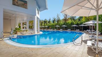 Piscina a l'aire lliure de temporada, para-sols i gandules