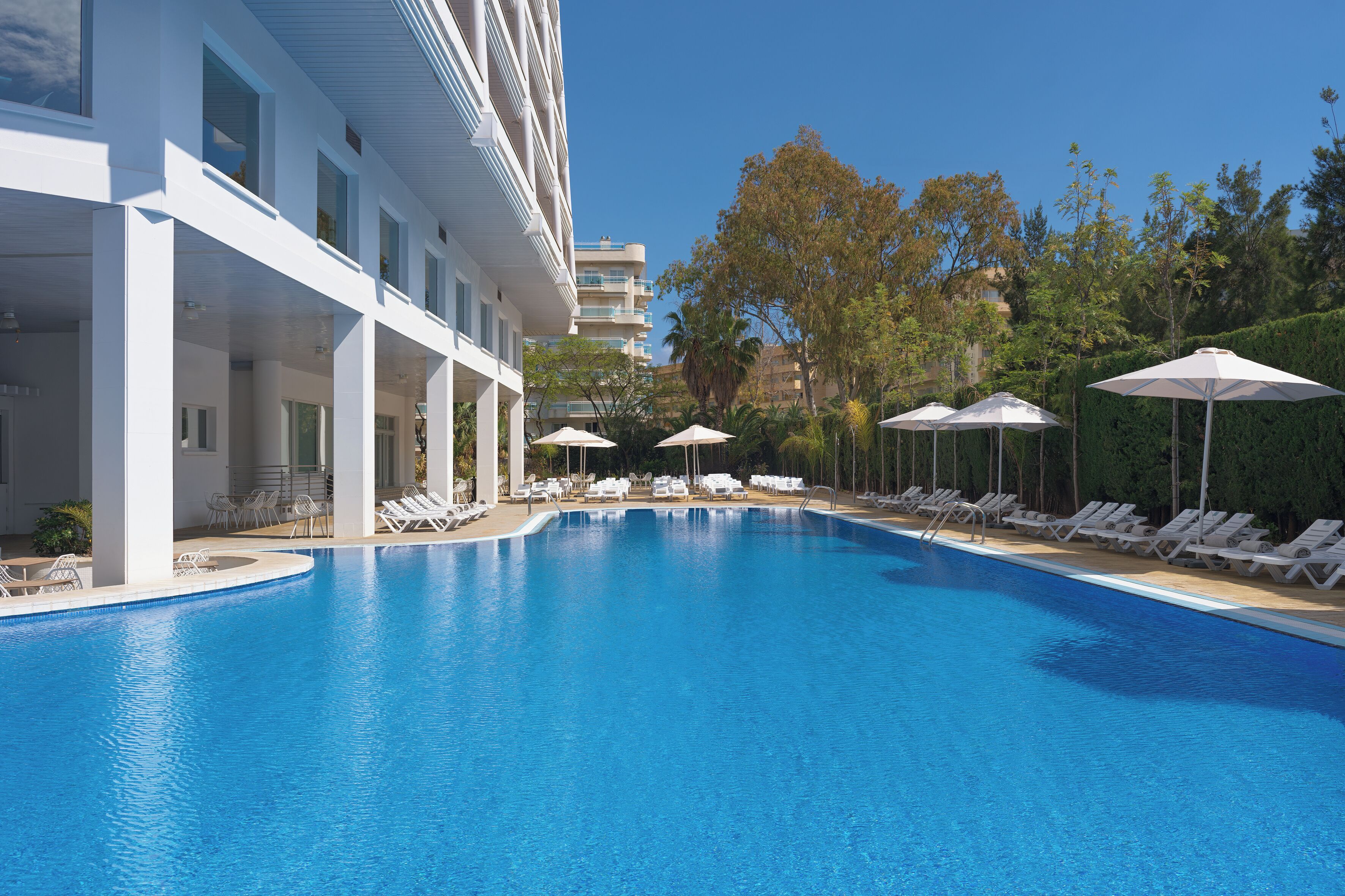 Een seizoensgebonden buitenzwembad en parasols bij het zwembad