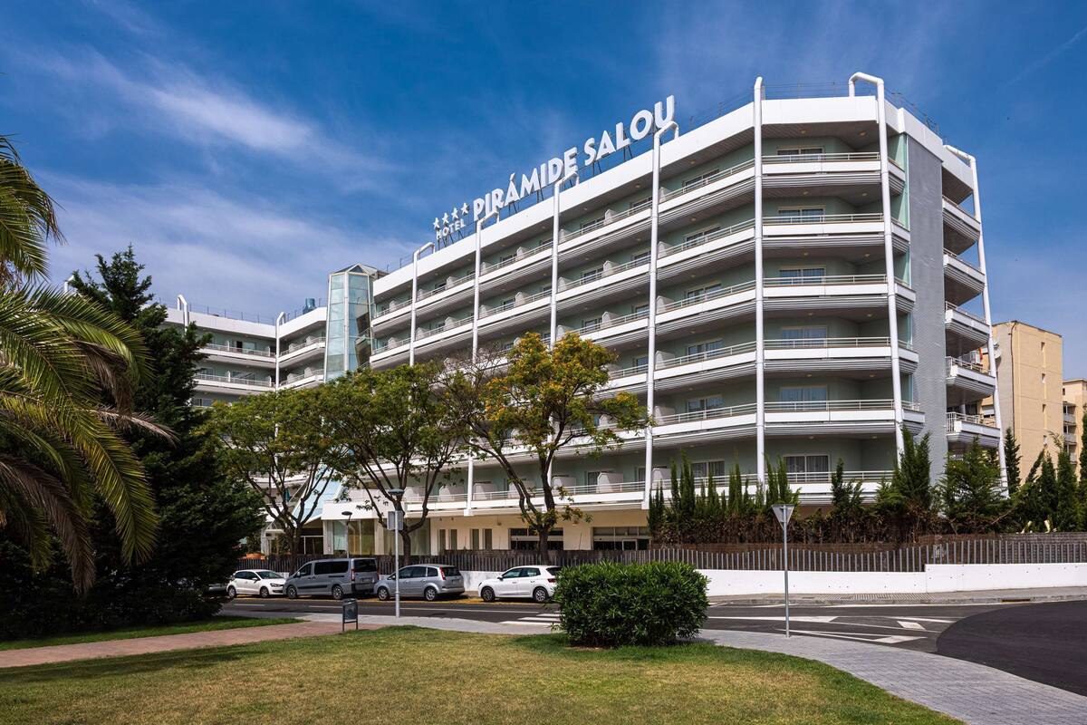 A multi-story hotel with balconies and a clear sky.