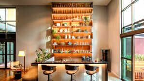 Una cocina moderna con barra, que incluye una vinoteca, taburetes de bar y diversos electrodomésticos.