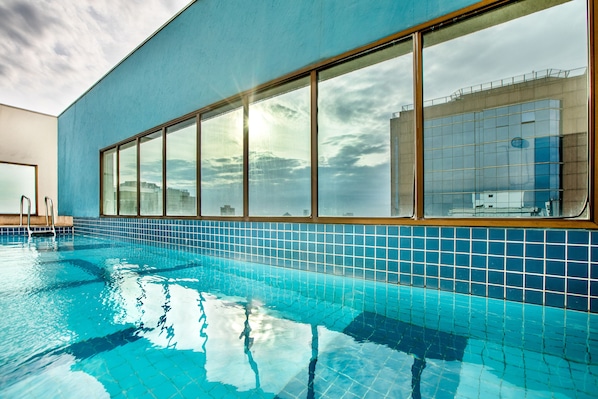 Una piscina al aire libre, sillones reclinables de piscina