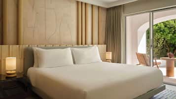 A hotel room with a large bed, two bedside lamps, a view of greenery through a sliding door, and a modern wall design.