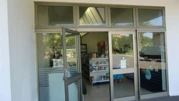 Une entrée d’immeuble avec une porte et des fenêtres en verre.