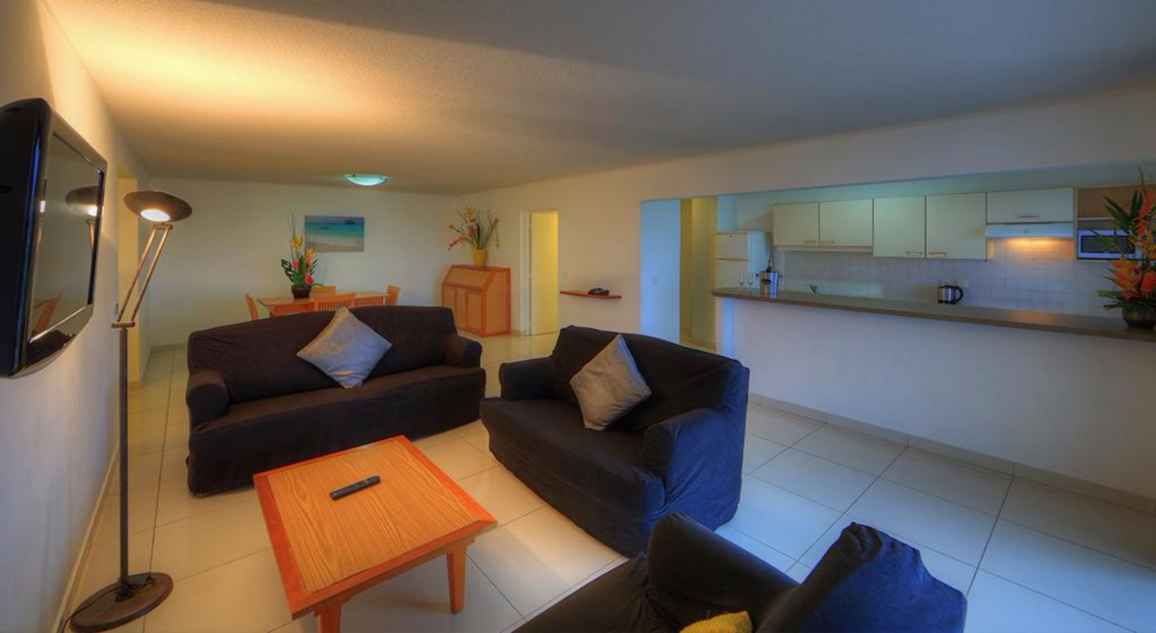 Un espacio habitable pequeño con un conjunto de sofá, una mesa pequeña y una zona de cocina.