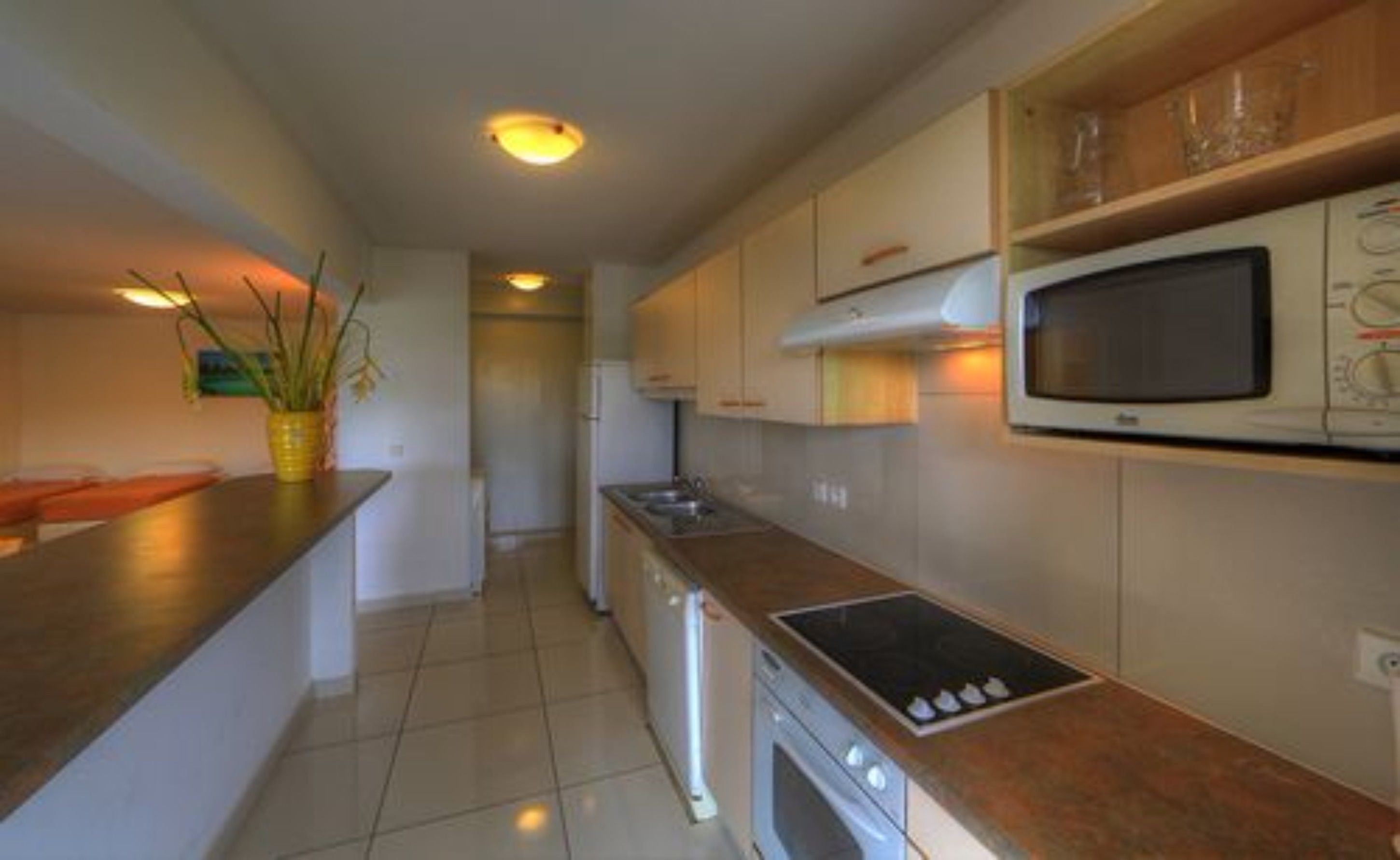 A modern kitchen with a microwave, stove, and sink.