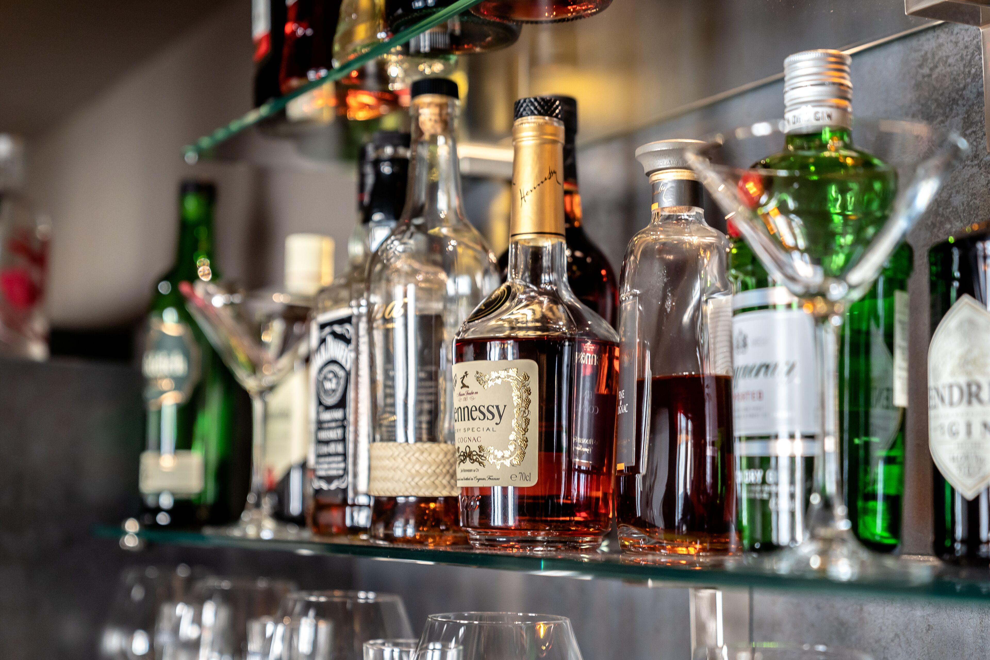 A bar with various bottles of liquor and glasses.