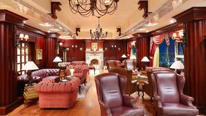 A luxurious room with a grand chandelier, plush seating, and a fireplace.