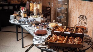 A buffet table with various food items and containers, including a cake and pastries. - Phi Hotel Emilia (Ozzano dell'Emilia)