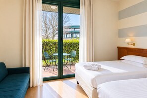 Une chambre d’hôtel avec un lit, un canapé et une vue sur l’espace extérieur.