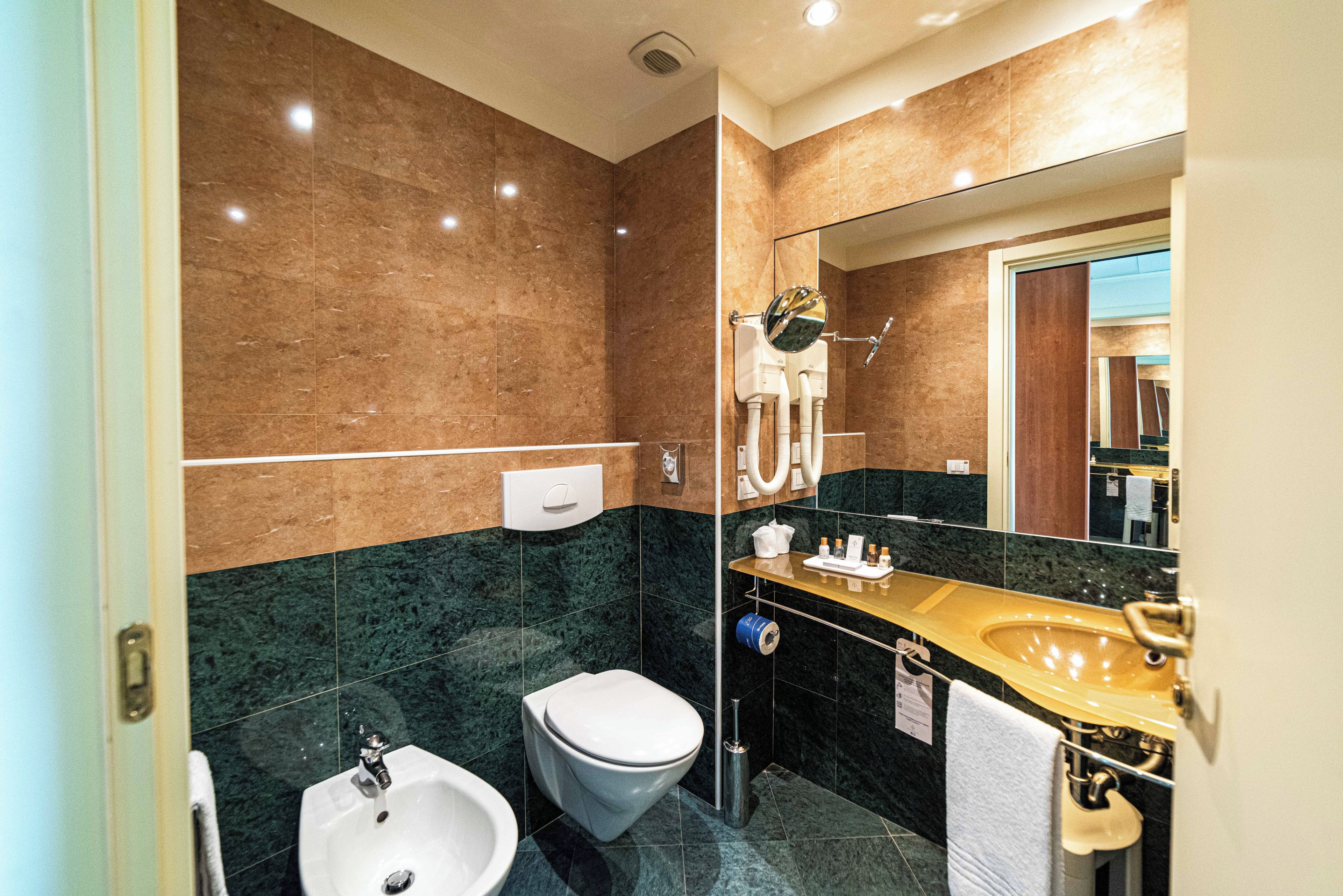 A modern bathroom with a toilet, bidet, and sink.
