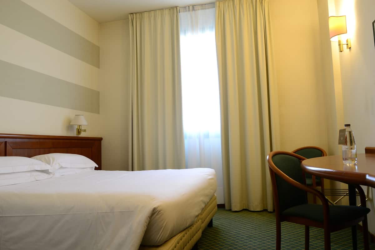 Ein Hotelzimmer mit einem Bett, einem Tisch und einem Stuhl.