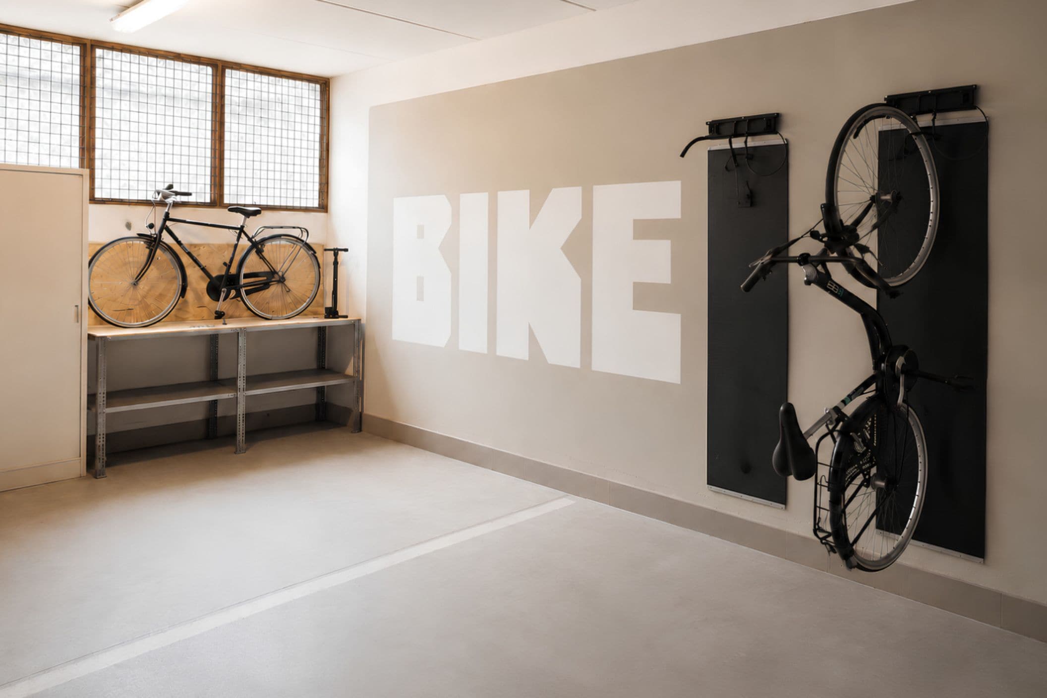 A clean, modern room with a large wall-mounted bike rack and a bike on the floor.