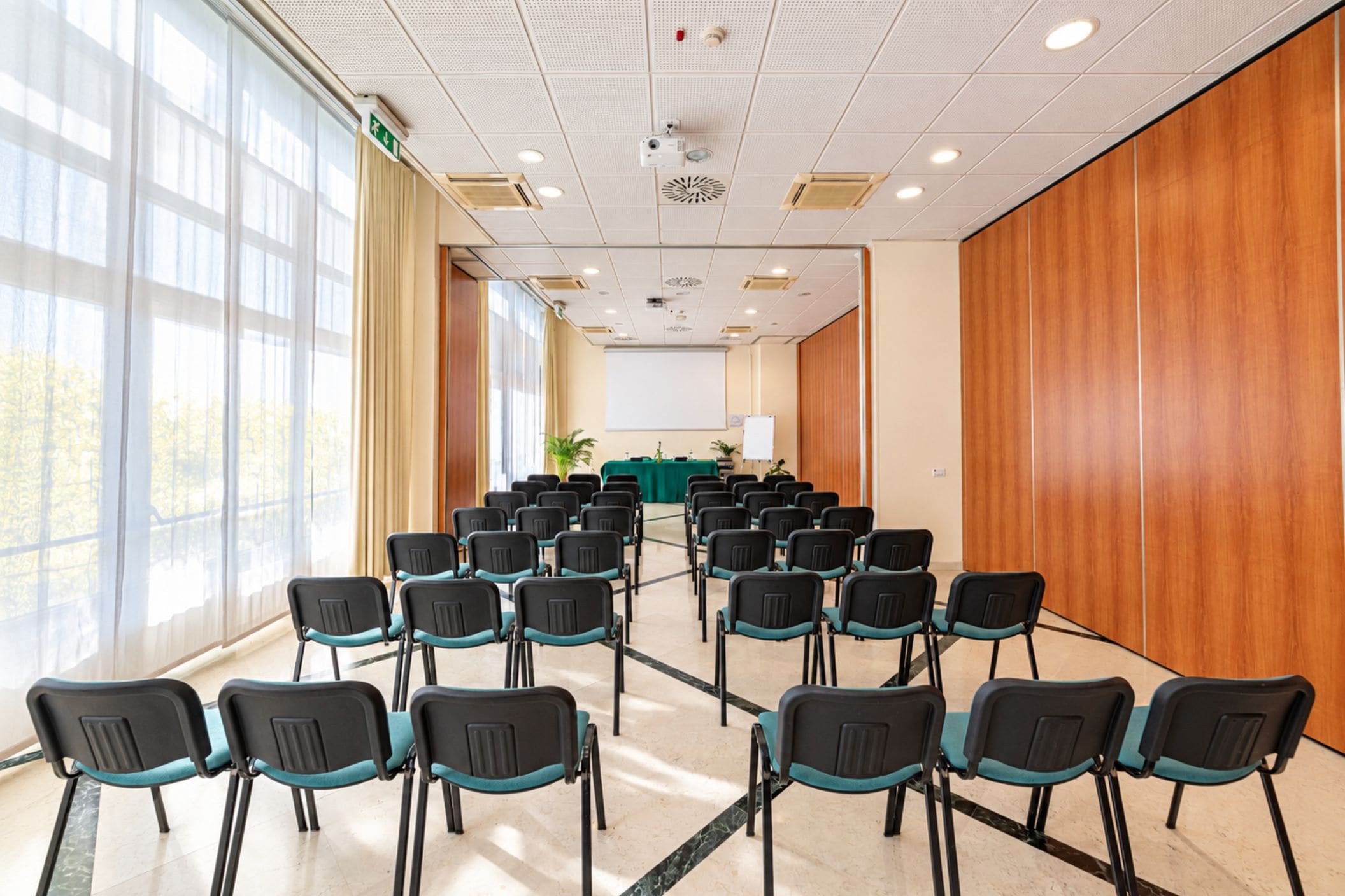 A conference room with rows of chairs, a projector, and a whiteboard.