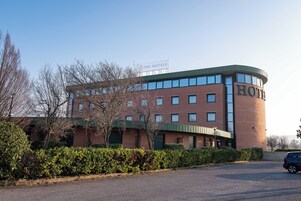 Un hotel con fachada curva, varias ventanas y un letrero que indica que pertenece a la cadena PHI HOTELS.