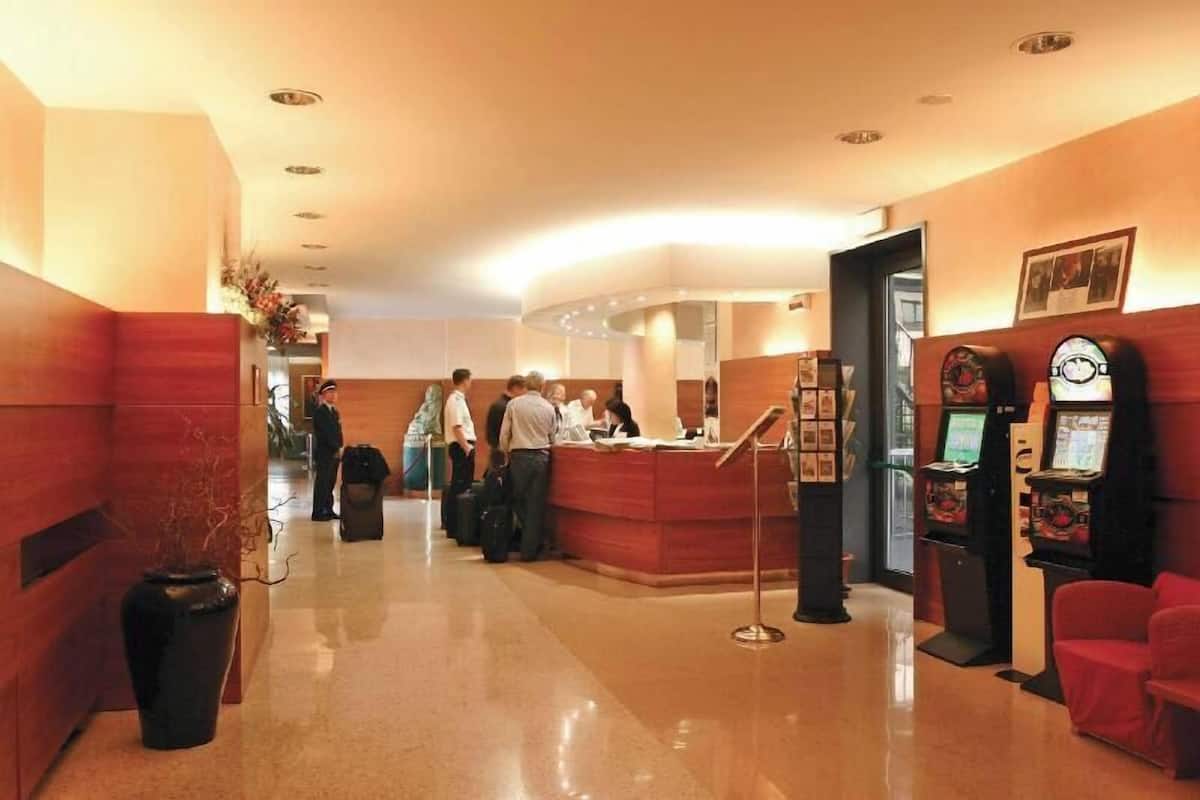 A hotel lobby with a reception desk, a red seating area, and a vending machine.