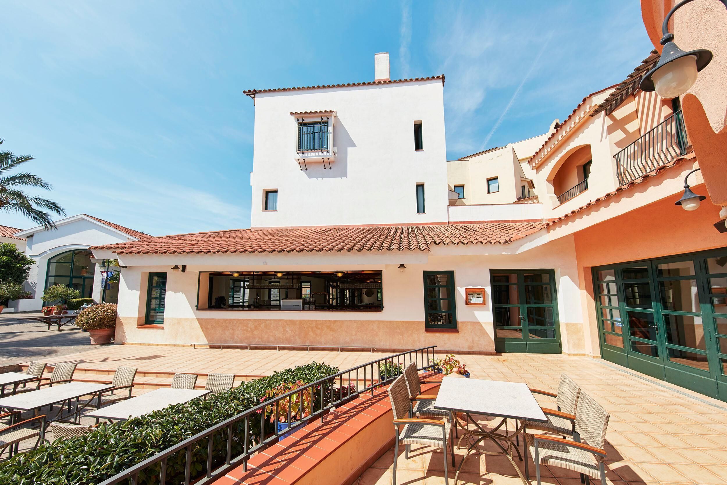 A building with a terrace, outdoor seating, and a restaurant.