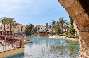 Un resort con piscina, palmeras y edificios de varios pisos.