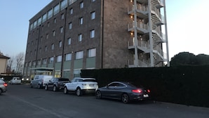 Un edificio de varios pisos con diseño moderno, que presenta una escalera central y varios balcones.