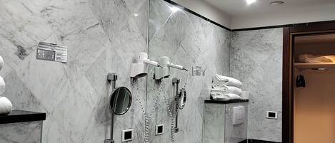 Un baño moderno con salpicadero de mármol, un espejo grande, un lavabo y un perchero para toallas.
