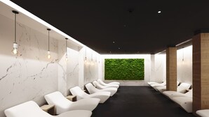 A modern spa room with white chairs arranged in rows, a green wall feature, and marble-patterned walls. - Grand Hotel Duca D'Este (Tivoli)