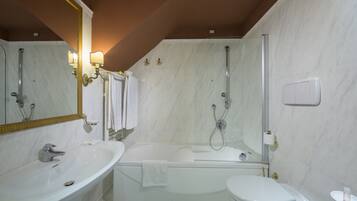 Ein modernes Badezimmer mit Waschbecken, Toilette und Badewanne in Weiß.