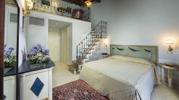 Ein Schlafzimmer mit einem großen Bett, einer Holztreppe und einem kleinen Tisch mit Lampe.