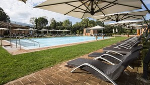 A poolside area with lounge chairs, umbrellas, and a swimming pool. - Hotel Il Piccolo Castello (Monteriggioni)