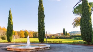 A fountain in a park with tall trees and a clear sky. - Hotel Il Piccolo Castello (Monteriggioni)