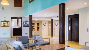 A lobby with seating, a reception desk, and a television. - Résidence Pierre & Vacances Premium Port-Prestige (Antibes)